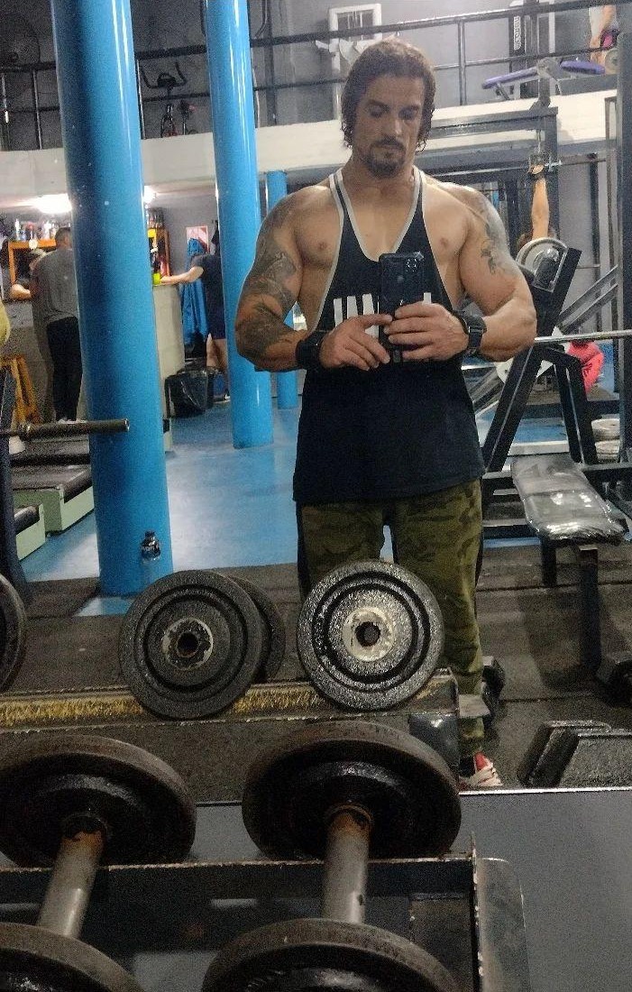 Socio de MaxFIT Gimnasio entrenando con pesas